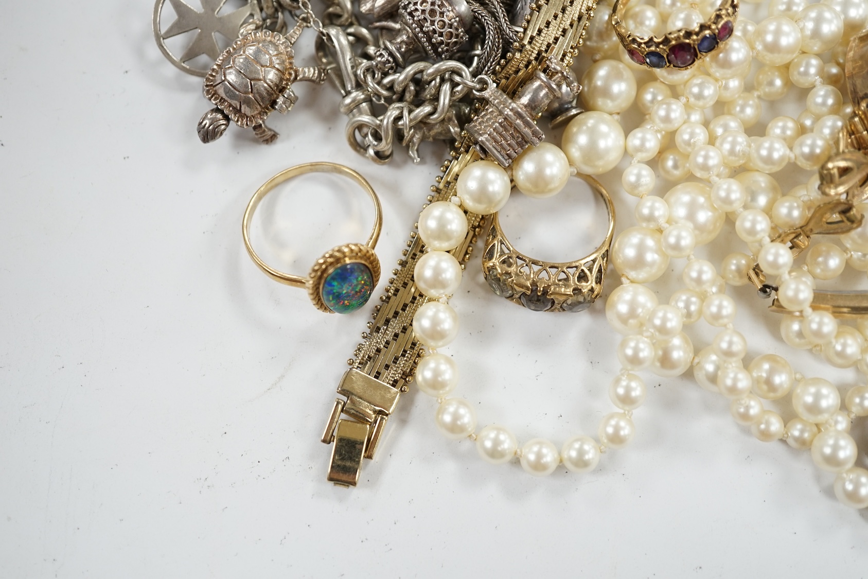 Four assorted modern 9ct and gem set rings, a 9ct and gem set pendant, a 9ct chain with yellow metal pendant, a silver charm bracelet and a small quantity of costume jewellery. Condition - poor to fair